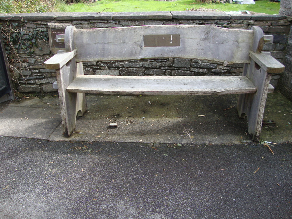 A handmade outdoor bench at a bus stop near Llanrhystud, Wales. It is dedicated to the memory of a local resident who died some fifty years ago. 